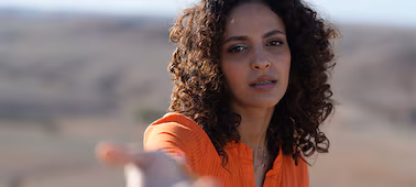 Example image of a female model stretching her right arm towards the camera, with bokeh foreground and background