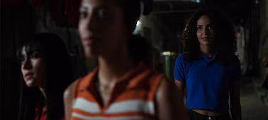 Example image of three women in the dark with the furthest from the camera in sharp focus, demonstrating precise subject tracking